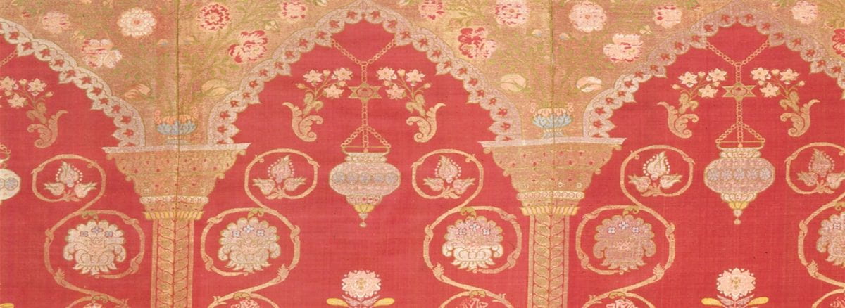 Detail of textile with deep red ground and design of arches