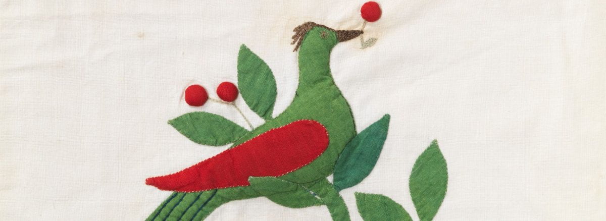 Detail of white quilt square with red and green bird motif.