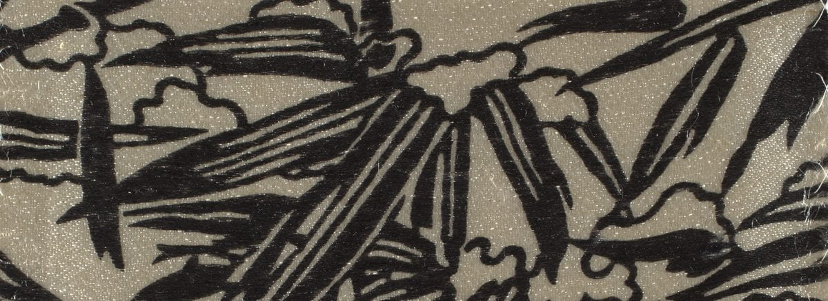 White textile fragment with print of overlapping black bamboo leaves.