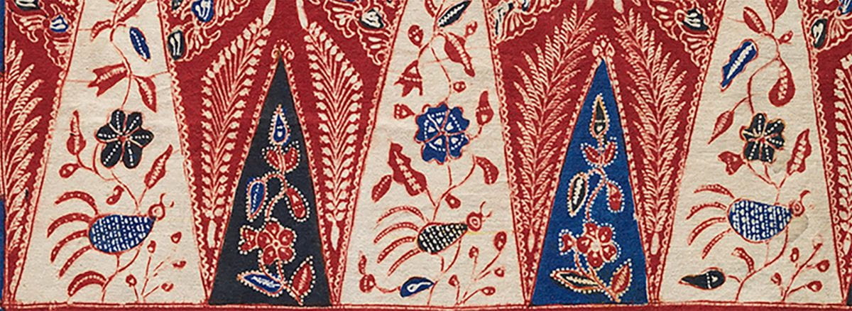 Bold red, blue, and white geometric pattern with floral motifs on batik fragment.